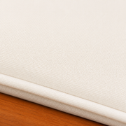Cushion texture | close view of the plain cream woven cover, self-piping, and eucalyptus rail