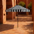 In a room | open black and white striped umbrella in a terracotta arched courtyard