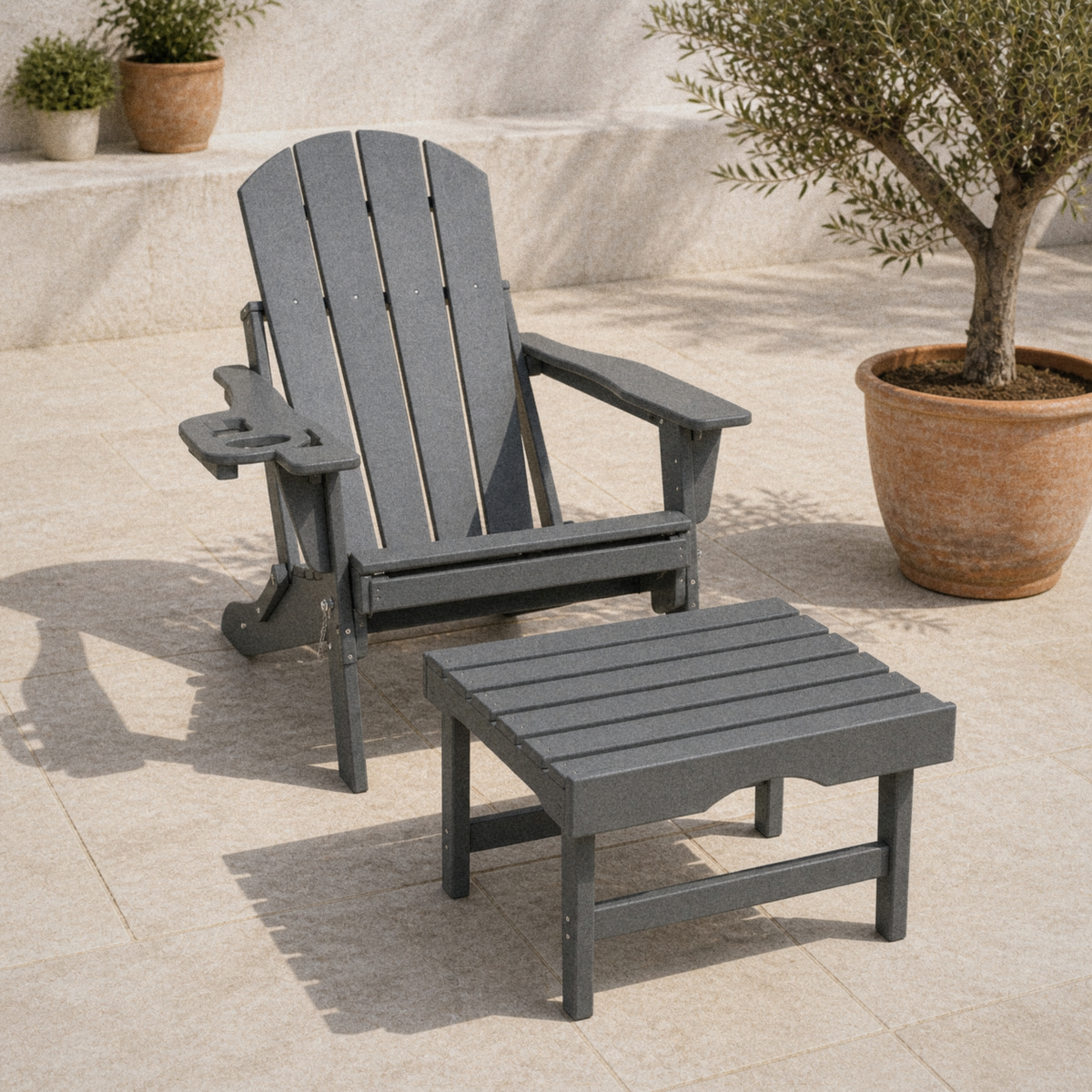Room | gray HDPE folding Adirondack chair and matching ottoman on limestone pavers beside a terracotta olive tree