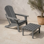 Set complete | gray HDPE Adirondack chair and matching ottoman together on the limestone terrace