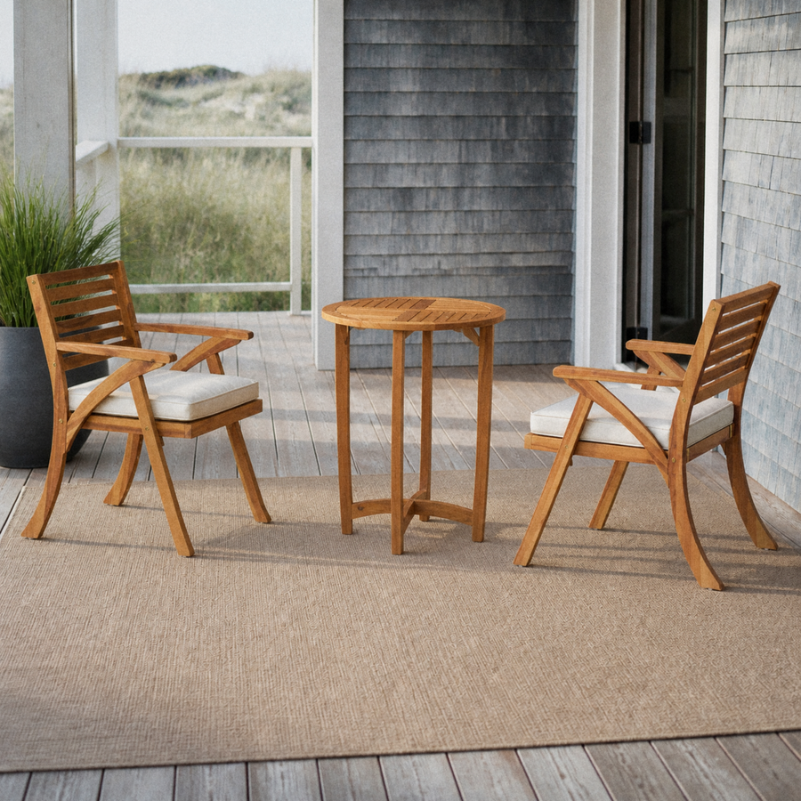 On a cedar porch | the two acacia armchairs and round table against blue-gray shingles