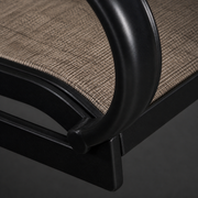 Close detail | black curved tubular arm joining the brown sling seat frame