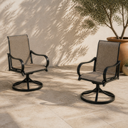 Terrace angle | two brown sling swivel dining armchairs on pale limestone pavers beside an olive in a terracotta pot