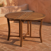 Room | Open eucalyptus folding table on a terracotta courtyard with brick paving and a plaster bench
