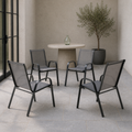 In a room | four Gray stacking armchairs on a cool limewash veranda, with blue-gray stone and a black-framed doorway