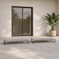 Scale | two low flat chaise lounges in front of a full-height glass doorway