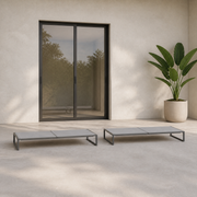 Scale | two low flat chaise lounges in front of a full-height glass doorway