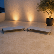 Set | two flat pale-gray mesh chaise lounges on a roof terrace