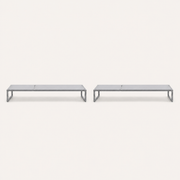 Front | two flat pale-gray mesh chaise lounges with dark gray iron rails on a studio sweep