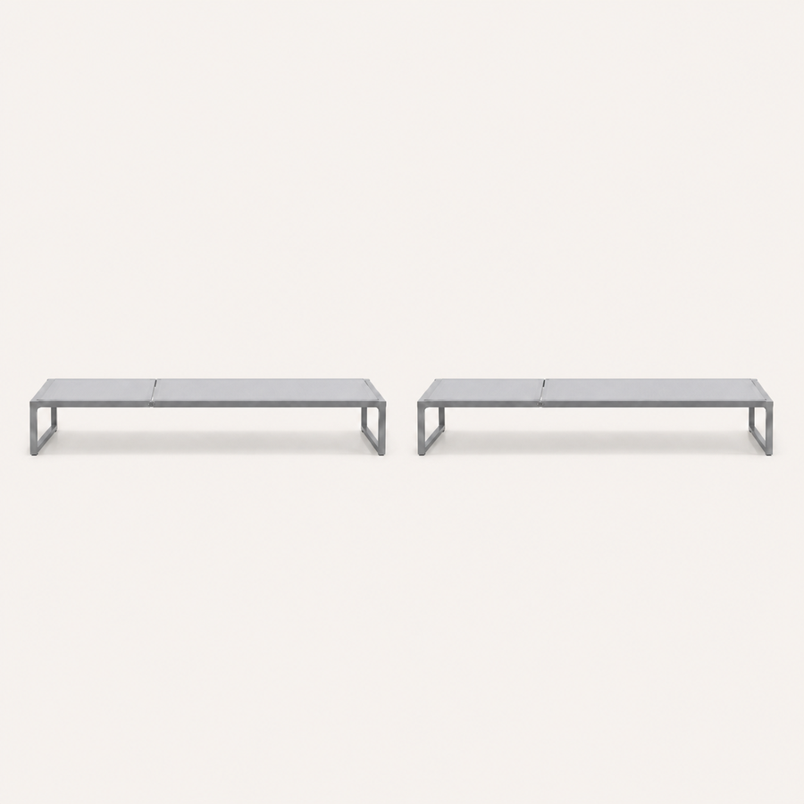 Front | two flat pale-gray mesh chaise lounges with dark gray iron rails on a studio sweep