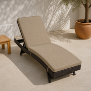 Angle | elevated foot-end view of the dark woven chaise lounge on limestone pavers