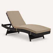 Studio | studio three-quarter view of the dark woven chaise lounge showing the curved side rail and splayed legs
