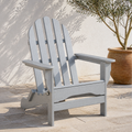 Terrace | light-gray folding Adirondack chair on limestone pavers beside white stucco and an olive tree