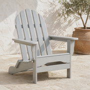 Terrace angle | light-gray folding Adirondack chair on limestone pavers in front of white stucco