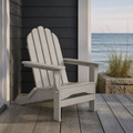 Coastal porch | light-gray folding Adirondack chair on a gray deck beside dark clapboard and an ocean opening