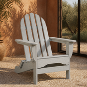 Garden room | light-gray folding Adirondack chair on pale gravel beside terracotta plaster and planting