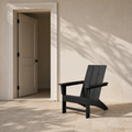 Scale | black HDPE Adirondack chair beside an uncropped doorway on a covered porch