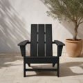 In a room | black HDPE Adirondack chair on a limestone terrace beside a terracotta olive planter