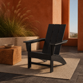 In a room | black HDPE Adirondack chair in a terracotta courtyard with a plain oatmeal rug and raised grass planter