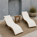 In a room | blue-gray courtyard with two ivory-cushioned acacia chaise lounges and a folding side table