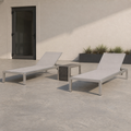In scale | full chaise lounge set beside an uncropped black exterior doorway on a concrete patio