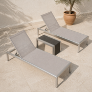 Complete set | both reclining chaise lounges and the woven side table from a high patio angle