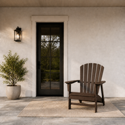 Scale | one mahogany fan-back Adirondack chair beside a full-height glazed exterior doorway on a covered patio
