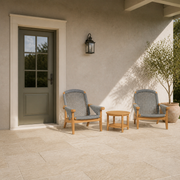 In scale | two teak Adirondack chairs and round side table beside a full-height exterior doorway