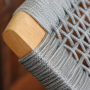 Close view | gray woven rope, raised basket weave and rounded natural teak chair arm cap