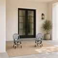 Scale | two black-and-white woven bistro dining chairs beside a full-height black patio door