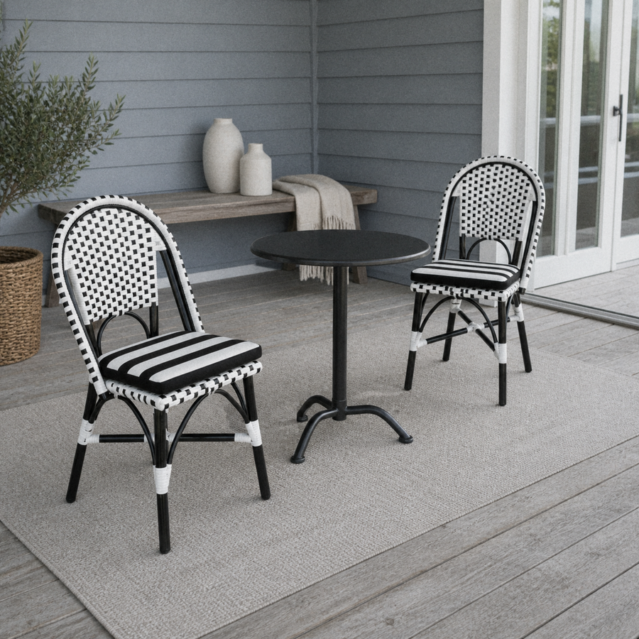 In a room | two black-and-white woven bistro dining chairs at a black cafe table on a blue-gray porch