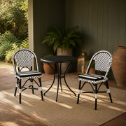 In a room | two black-and-white woven bistro dining chairs at a black bistro table on a sage green veranda