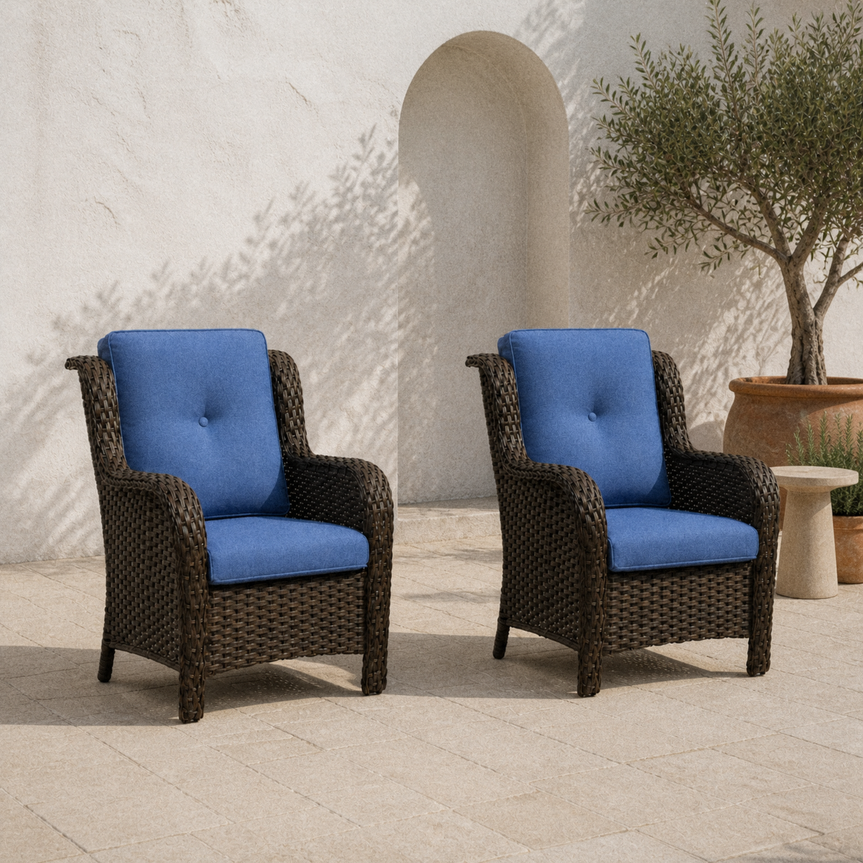 Courtyard | two blue-cushioned brown wicker patio chairs on sunlit limestone beside an olive planter