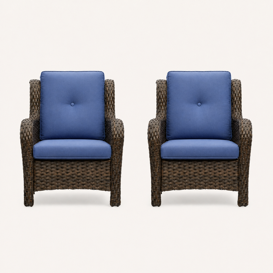 Front | two matching blue-cushioned brown wicker patio chairs on a warm white studio sweep