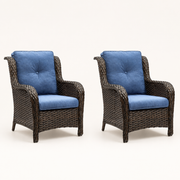 Three-quarter | two matching brown wicker patio chairs with blue cushions on a studio sweep