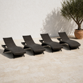 In a room | four dark brown woven folding chaise lounges on a sunlit limestone terrace beside an olive tree