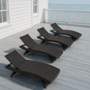 In a room | four dark brown woven folding chaise lounges on a cool coastal veranda