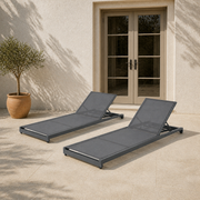 Scale | two gray mesh chaise lounges on a patio with a full-height doorway behind them