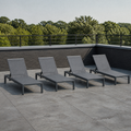 Room 2 | four dark charcoal aluminum chaise lounges on a cool rooftop terrace, each with a grey mesh sling