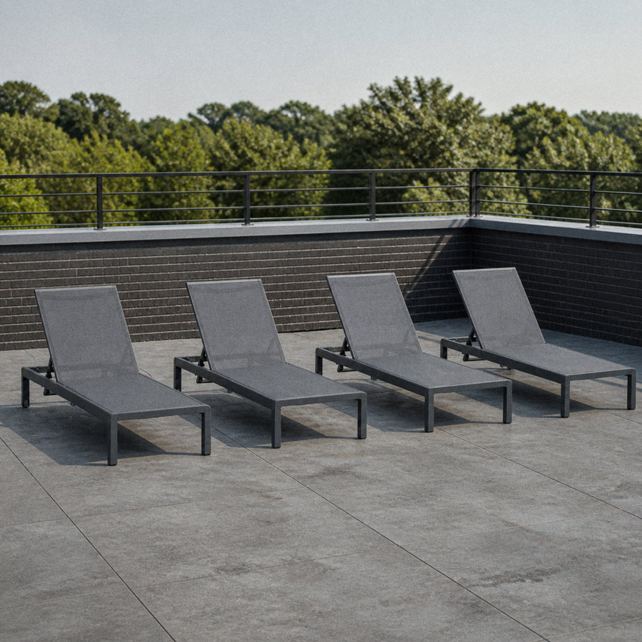 Room 2 | four dark charcoal aluminum chaise lounges on a cool rooftop terrace, each with a grey mesh sling