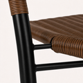 Wrapped arm and brace detail | close detail of brown rattan wrap over a black tube, woven seat edge and black cross braces