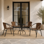 Scale | four Medium Brown woven-rattan armchairs around a cafe table beside a full-height glass doorway