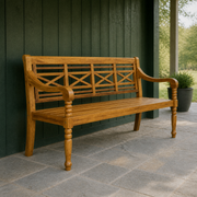 Covered porch | natural acacia garden bench on gray stone beside deep green timber cladding