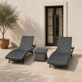 Scale | two charcoal-gray woven chaise loungers and a matching side table beside a full-height glass doorway