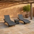In a room | two charcoal-gray woven chaise loungers and a matching side table in a terracotta courtyard