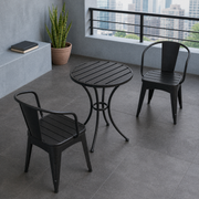 In a room | cool city balcony with black iron bistro table and two armchairs