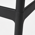 Footrest | close view of black molded-plastic footrest rail and leg junction