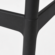 Footrest | close view of black molded-plastic footrest rail and leg junction