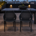 Rooftop dining | two matte-black open-mesh armchairs at a slate table on a cedar deck