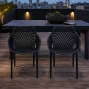 Rooftop dining | two matte-black open-mesh armchairs at a slate table on a cedar deck
